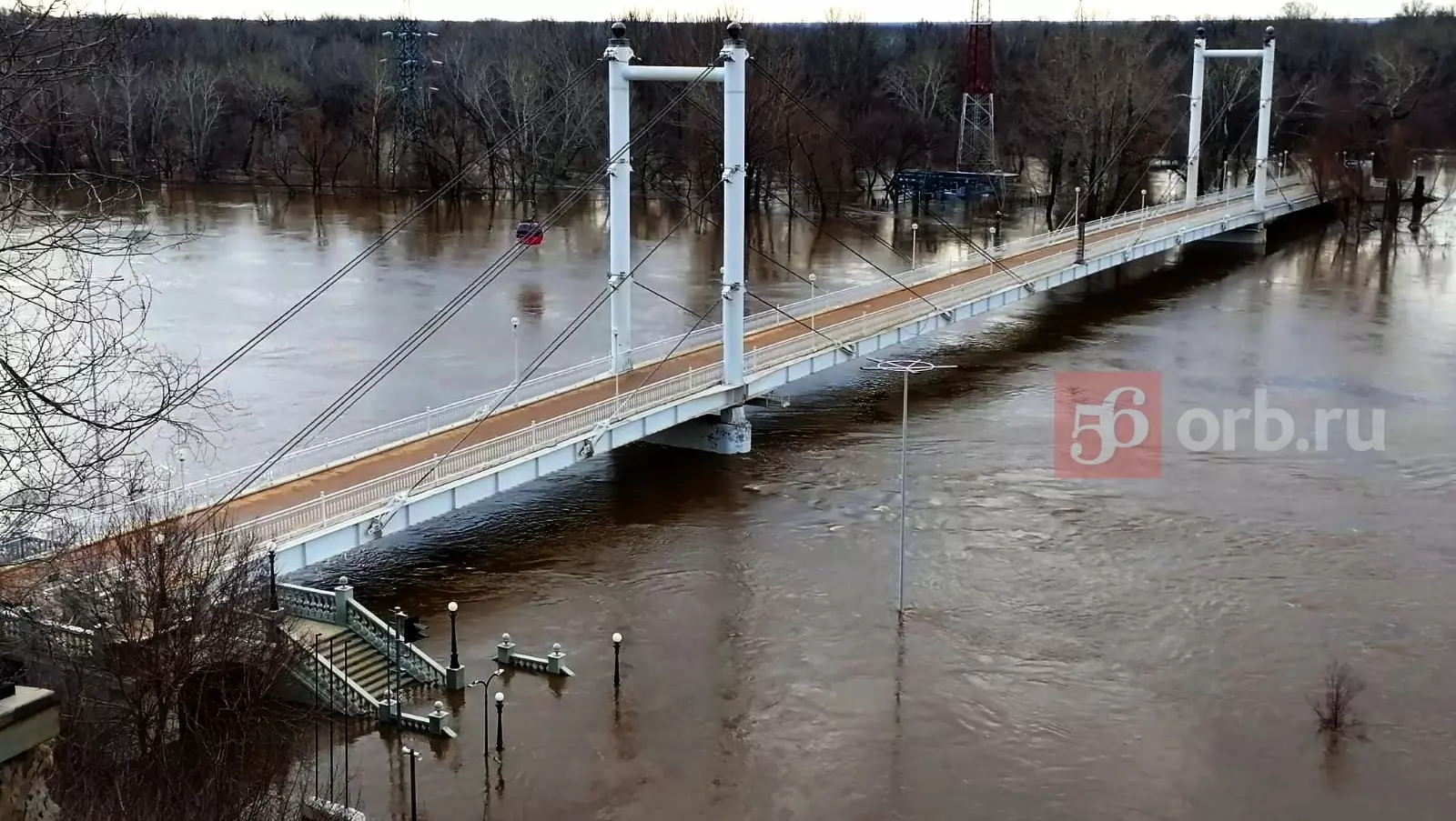 Пешеходный мост уже не нависает над водой, а практически лежит на ней