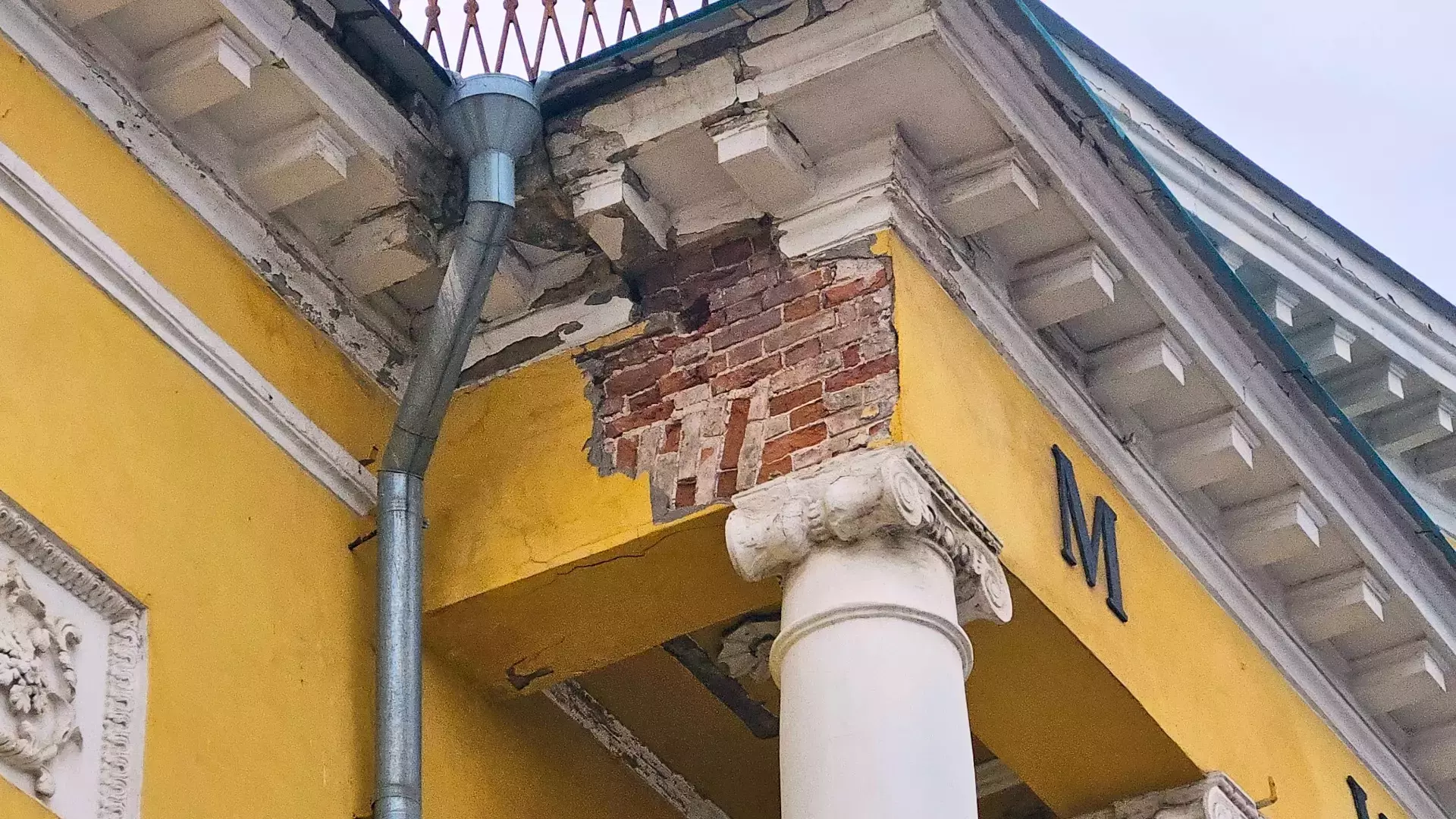 С фасада старинного здания обваливается штукатурка