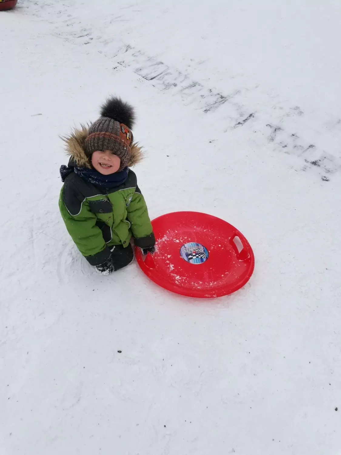 Ребенок развлекается зимой на детской площадке